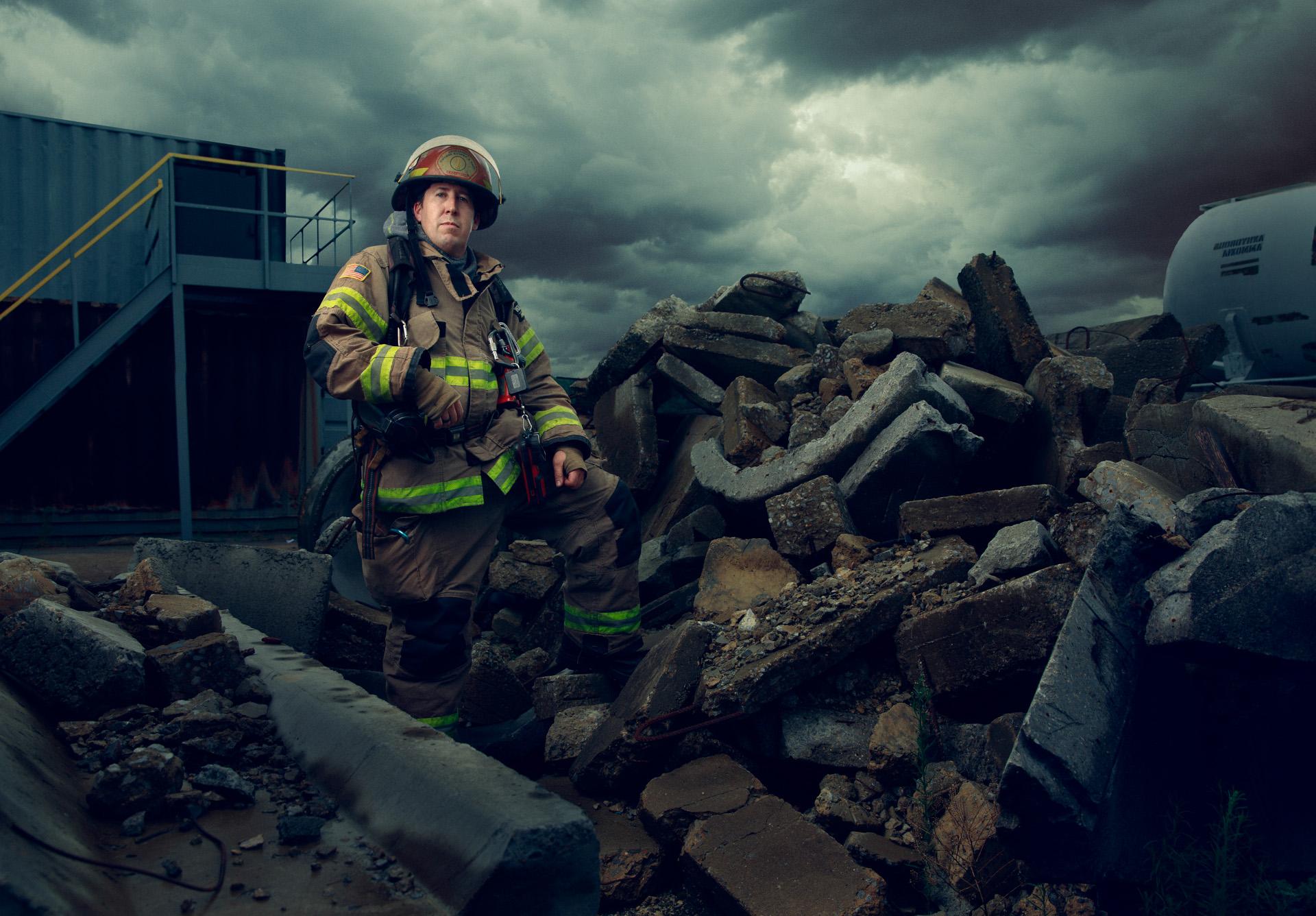 一名消防员站在一堆碎石上